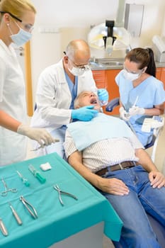 Senior man at dentist surgery having tooth operation stomatology clinic