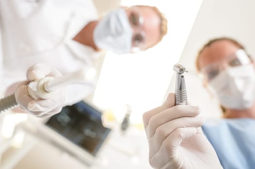 Female dentist focus on drill from patient point of view