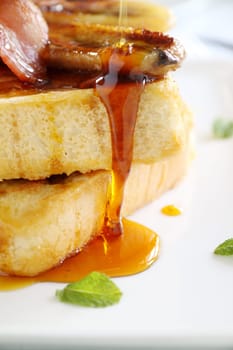 Maple syrup dripping down caramelized banana and french toast.