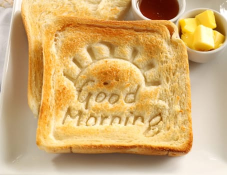 Slice of toast with Good Morning carved into it with butter and honey.