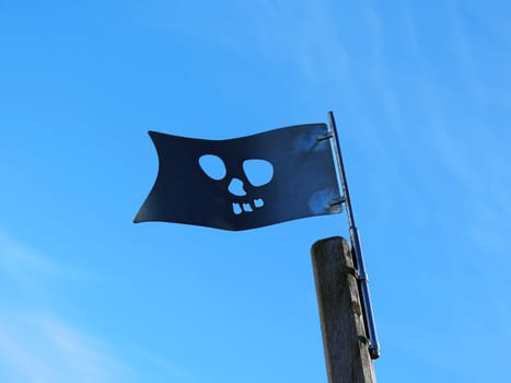 Flag of the pirates on the playground under blue sky - high contrast