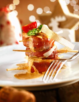Festive medallions of pork wrapped in bacon on a dish with a beautiful boketh background