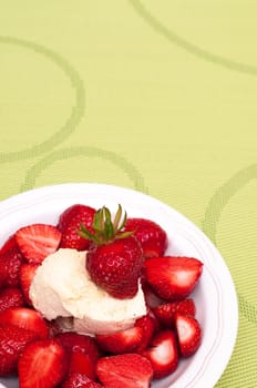 Green tablecloth with red strawberries and vanilla ice cream