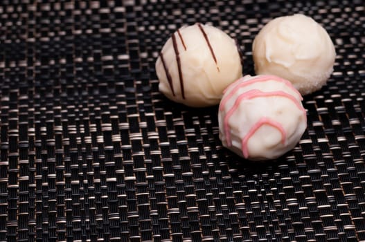 White chocolate truffle pralines on a dark background