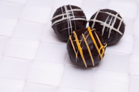 Brown chocolates made of chocolate on white braided fabric