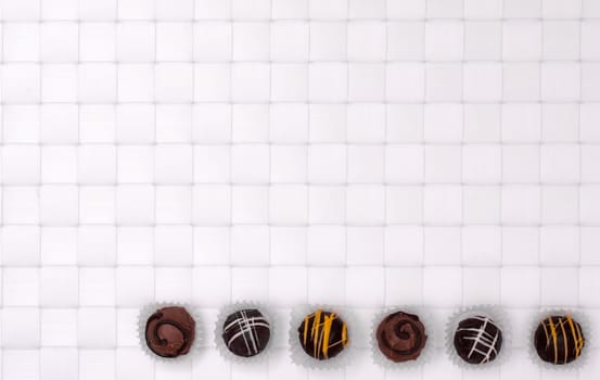 Brown Truffle Chocolates on a White Braided Background