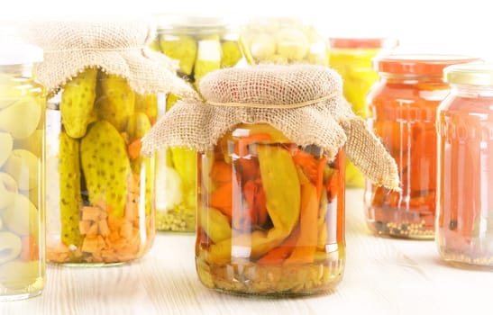 Composition with jars of pickled vegetables. Marinated food.