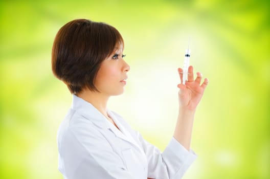 Asian beautician with syringe on green background