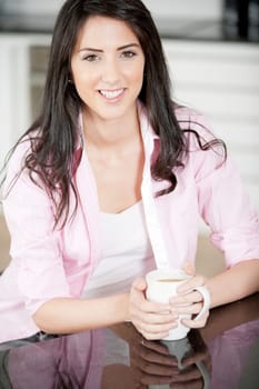 Young woman drinking a cup of coffee at home