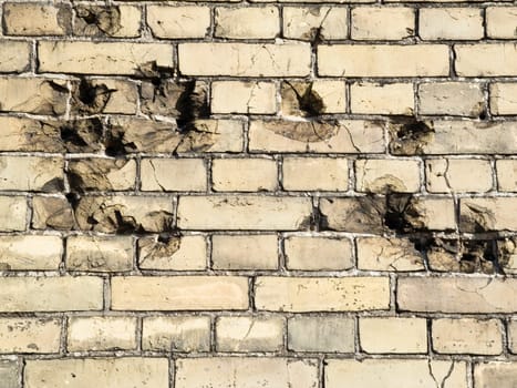 Bullet holes in old,yellowish brick wall as background