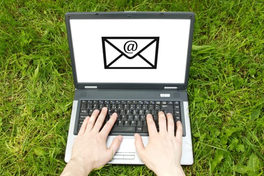 wireless techology usage concept. hands typing on a computer keyboard in a nature