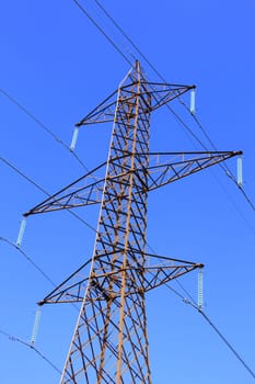 High voltage pylon in front of blue sky