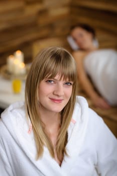 Close -up of young woman in bathrobe sitting at luxury spa