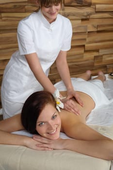 Beautiful brunette having back massage at luxury spa centre