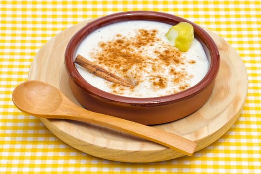 homemade rice with milk and cinnamon in a ceramic bowl, presentation with spoon