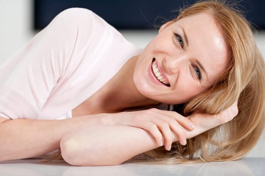 Young woman in pink shirt sitting at dining table at home