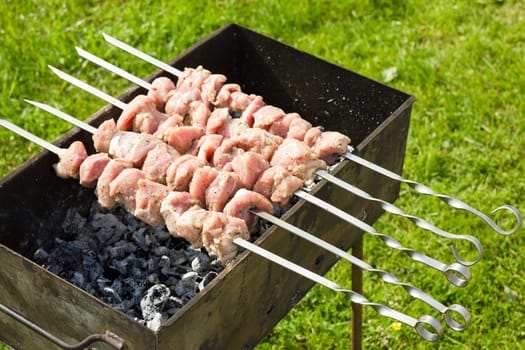 raw  meat pieces cooking on a skewer
