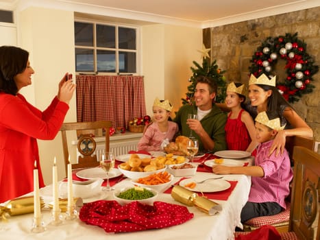 Hispanic family taking photos of Christmas dinner