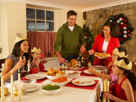Hispanic family serving Christmas dinner