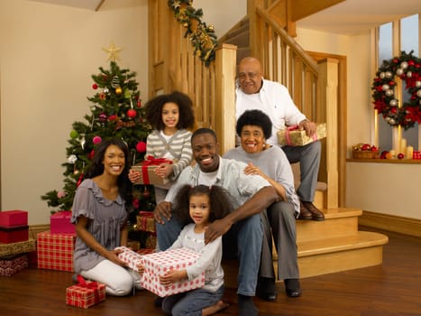 Mixed race family with Christmas tree and gifts