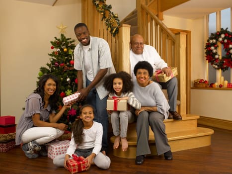 Mixed race family with Christmas tree and gifts