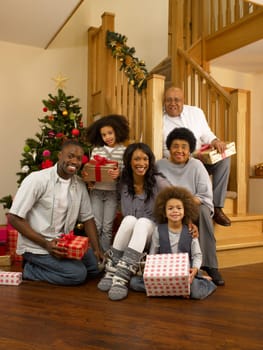 Mixed race family with Christmas tree and gifts