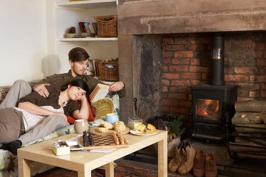 Young couple relaxing by fire