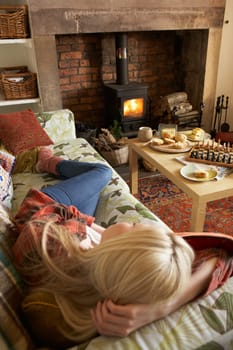Young woman relaxing by fire