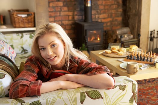 Young woman relaxing by fire