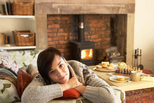Young woman relaxing by fire