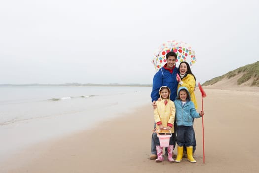 Happy family on beach with umbrella
