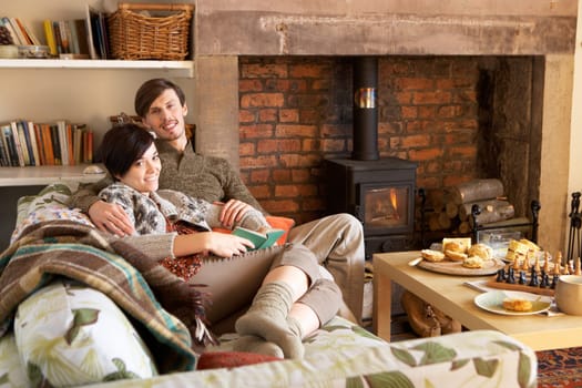 Young couple relaxing by fire