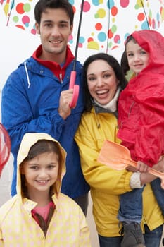 Happy family on beach with umbrella