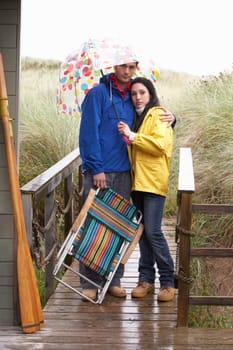 Young couple on beach with umbrella