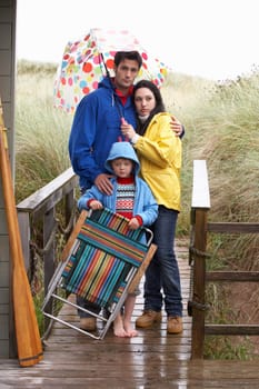 Family on beach with umbrella