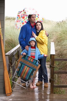 Family on beach with umbrella