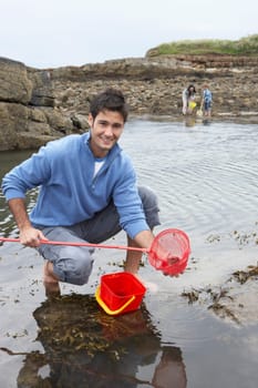 Young family at beach collecting shells