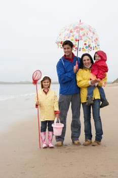 Happy family on beach with umbrella
