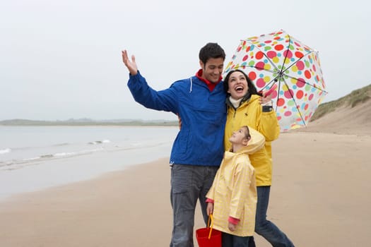 Happy family on beach with umbrella