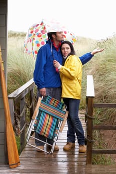 Young couple on beach with umbrella