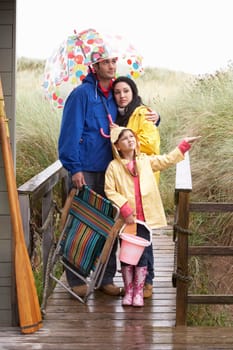 Family on beach with umbrella