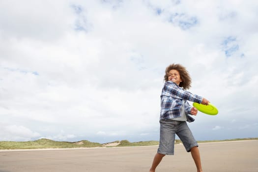 Boy playing frisbee on beach