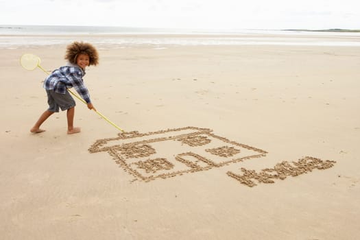Boy drawing in sand