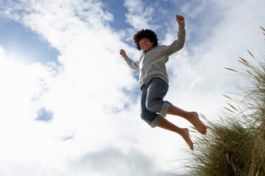 Boy jumping over dune