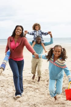Happy family running on beach