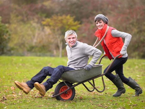 Young couple playing in wheelbarrow