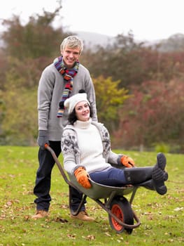 Young couple playing in wheelbarrow