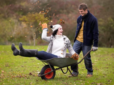 Young couple playing in wheelbarrow