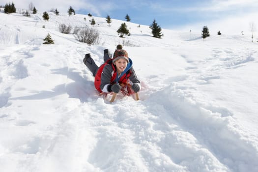 Pre-teen Boy On A Sled In The Snow