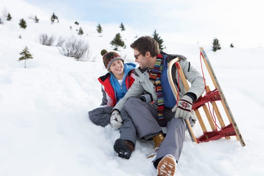 Young Father And Son In Snow With Sled